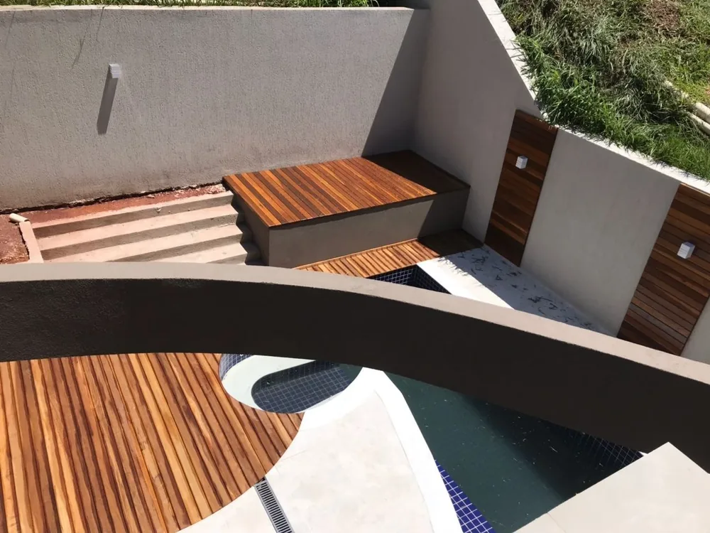 Área externa com deck em madeira e piscina, obra da HA Engenharia